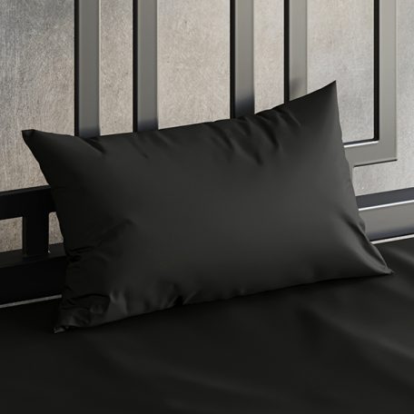 Close up of a Sheets of San Francisco Black waterproof pillow case on a bed covered in a Black Sheets of San Francisco fluid proof fitted sheet and against a black metal bedhead with the polished concrete wall behind showing through.
